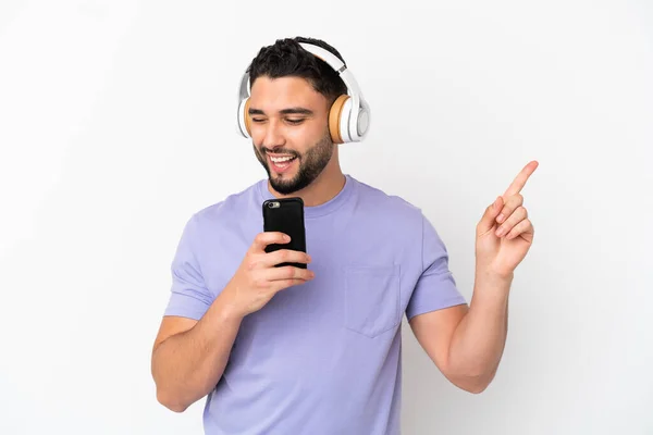 Jovem Árabe Homem Isolado Fundo Branco Ouvir Música Com Celular — Fotografia de Stock