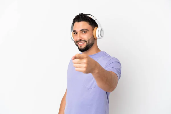 Ung Arabisk Man Isolerad Vit Bakgrund Lyssna Musik Och Pekar — Stockfoto