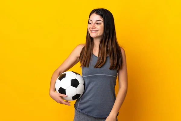 Молода Жінка Футболістка Ізольована Жовтому Тлі Дивлячись Бік Посміхаючись — стокове фото