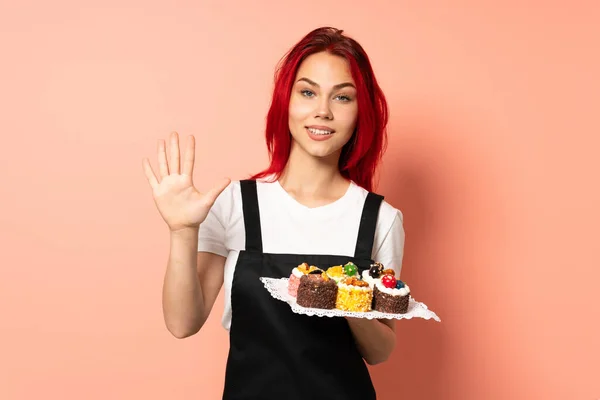 Pastelero Sosteniendo Muffins Aislado Sobre Fondo Rosa Contando Cinco Con —  Fotos de Stock