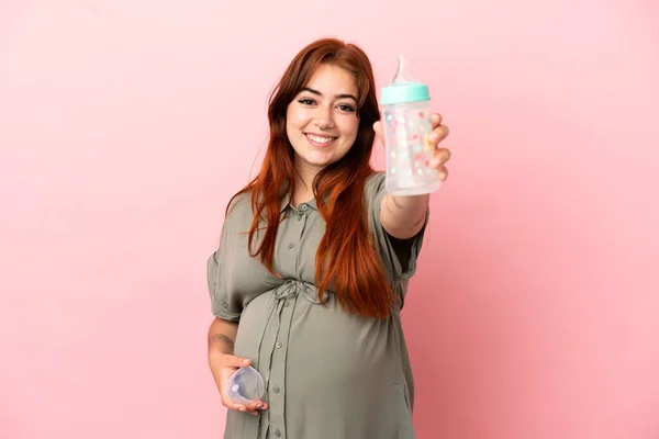 Giovane Rossa Donna Caucasica Isolata Sfondo Rosa Incinta Con Mano — Foto Stock