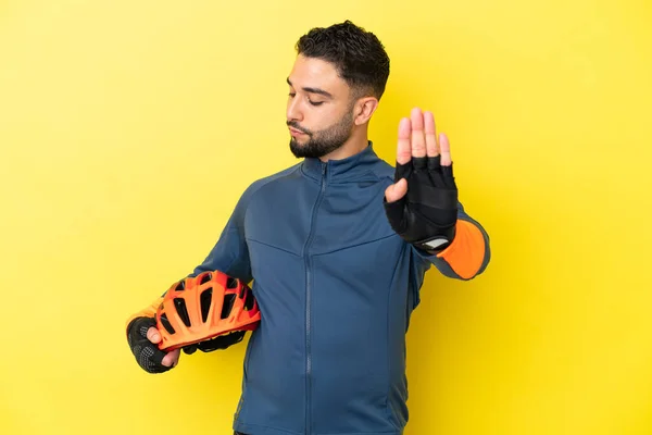 Joven Ciclista Árabe Aislado Sobre Fondo Amarillo Haciendo Stop Gesture —  Fotos de Stock