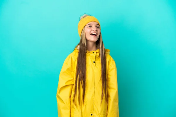 Niña Usando Abrigo Impermeable Sobre Fondo Azul Aislado Riendo —  Fotos de Stock