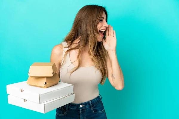 Femme Caucasienne Tenant Des Pizzas Hamburger Isolé Sur Fond Bleu — Photo