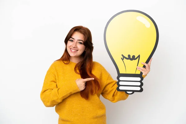 Young Redhead Woman Isolated White Background Holding Bulb Icon Pointing — Stock Photo, Image