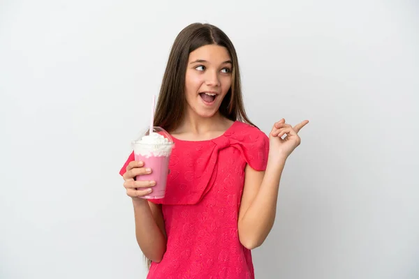 指を持ち上げながら解決策を実現しようとしている孤立した白い背景にイチゴミルクセーキと女の子 — ストック写真