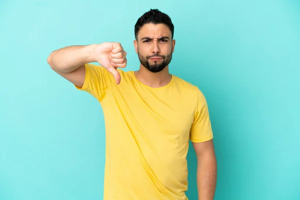 Jonge Arabische Man Geïsoleerd Blauwe Achtergrond Met Duim Naar Beneden — Stockfoto