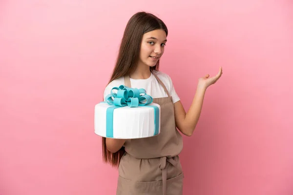 Menina Com Grande Bolo Sobre Fundo Rosa Isolado Estendendo Mãos — Fotografia de Stock