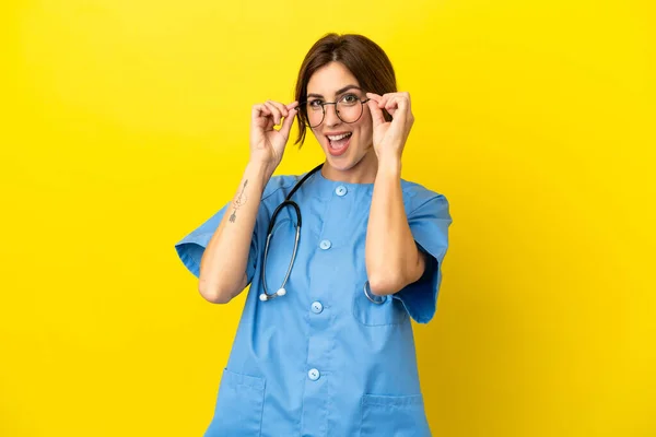 Lekarz Chirurg Kobieta Izolowana Żółtym Tle Okularami Zaskoczony — Zdjęcie stockowe