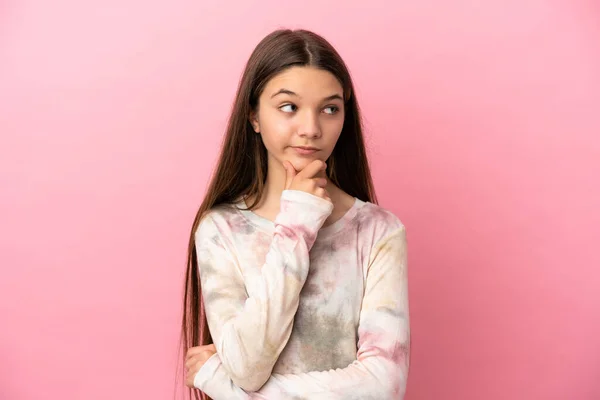 Menina Sobre Fundo Rosa Isolado Pensando Uma Ideia Enquanto Olha — Fotografia de Stock