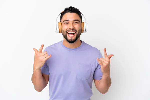 Νεαρός Άραβας Απομονωμένος Λευκό Φόντο Ακούγοντας Μουσική Κάνοντας Ροκ Χειρονομία — Φωτογραφία Αρχείου