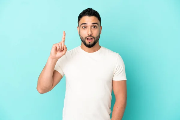 Ung Arabisk Man Isolerad Blå Bakgrund Tänker Idé Som Pekar — Stockfoto