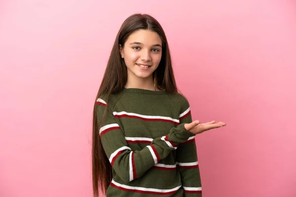 Menina Sobre Fundo Rosa Isolado Apresentando Uma Ideia Enquanto Olha — Fotografia de Stock