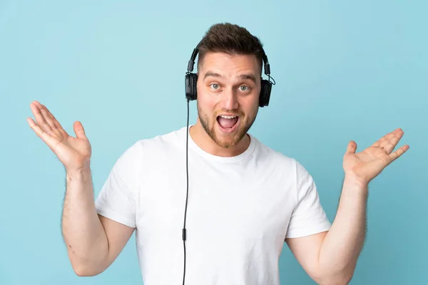 Russo Bonito Homem Isolado Fundo Azul Surpreso Ouvir Música — Fotografia de Stock