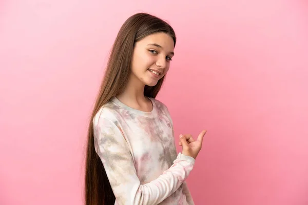 Kleines Mädchen Über Isoliertem Rosa Hintergrund Der Nach Hinten Zeigt — Stockfoto
