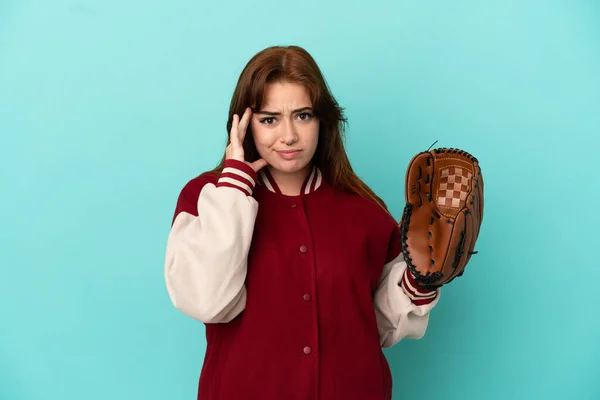 若い赤毛の女性が青い背景に隔離された野球をしている考え方 — ストック写真