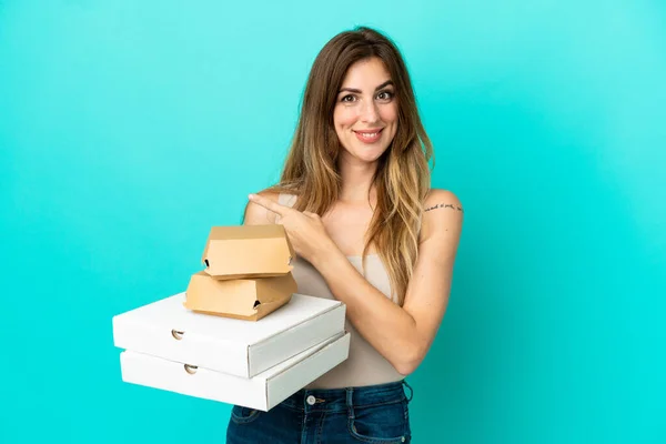 Femme Caucasienne Tenant Des Pizzas Hamburger Isolé Sur Fond Bleu — Photo