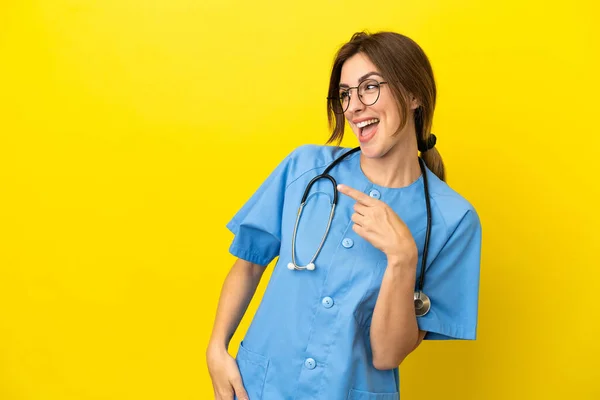 Chirurg Ärztin Isoliert Auf Gelbem Hintergrund Zeigt Mit Dem Finger — Stockfoto