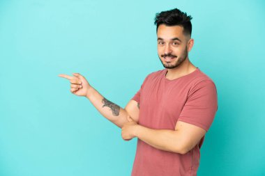 Kafkasyalı genç adam mavi arka planda izole edildi.