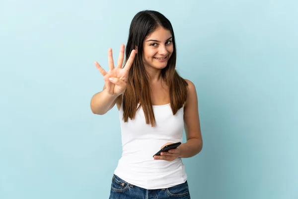 Νεαρή Καυκάσια Γυναίκα Που Χρησιμοποιεί Κινητό Τηλέφωνο Απομονωμένο Μπλε Φόντο — Φωτογραφία Αρχείου