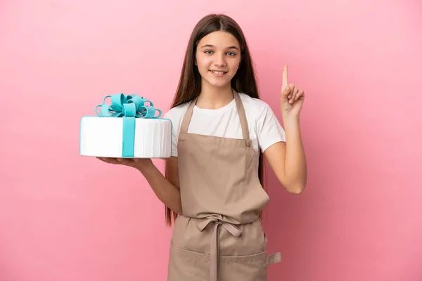 Petite Fille Avec Gros Gâteau Sur Fond Rose Isolé Pointant — Photo