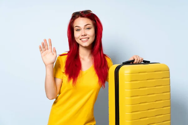 Viaggiatore Ragazza Possesso Una Valigia Isolata Sfondo Blu Saluto Con — Foto Stock