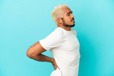 Genç Kolombiyalı yakışıklı adam mavi arka planda izole edilmiş.