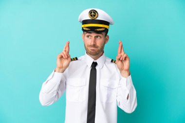 Kafkasyalı uçak pilotu mavi arka planda izole edilmiş ve şans diliyor.