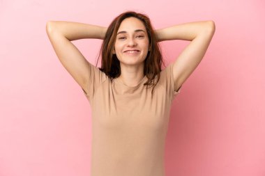 Pembe arka planda izole edilmiş genç beyaz kadın gülüyor.