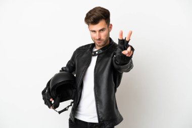 Beyaz arka planda izole edilmiş motosiklet kasklı beyaz adam gülümsüyor ve zafer işareti gösteriyor.
