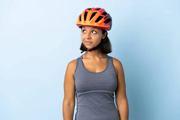 Mavi Arka Planda Izole Edilmiş Genç Bisikletçi Kadın Şüpheli Hareketler — Stok fotoğraf