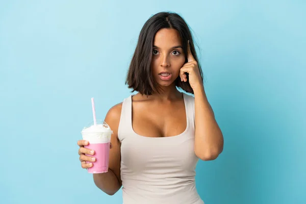 Mujer Joven Con Batido Fresa Aislado Sobre Fondo Azul Pensando —  Fotos de Stock