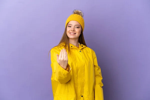 Chica Adolescente Con Abrigo Impermeable Sobre Fondo Púrpura Aislado Invitando —  Fotos de Stock