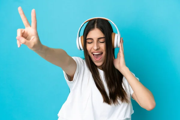 Joven Mujer Caucásica Aislada Sobre Fondo Azul Escuchando Música Cantando — Foto de Stock