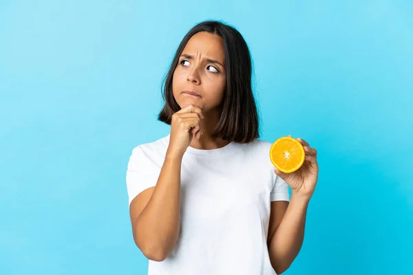 Junge Asiatische Mädchen Halten Eine Orange Isoliert Auf Blauem Hintergrund — Stockfoto