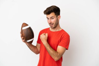 Beyaz arka planda ragbi oynayan beyaz bir adam zaferi kutluyor.