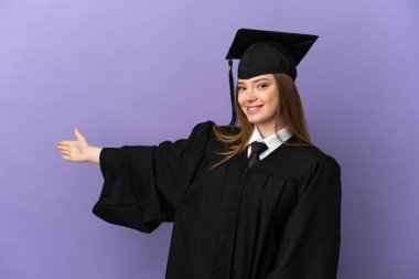 İzole edilmiş mor arka planda genç üniversite mezunu. Davet edilmek için ellerini yana uzatıyor.