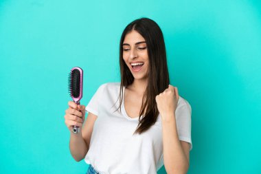 Mavi arka planda saçı taranmış beyaz bir kadın zaferi kutluyor.