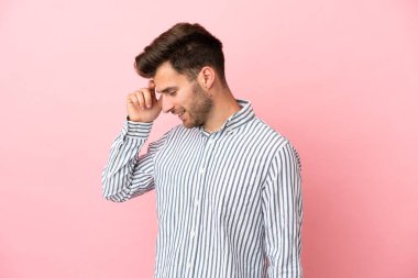 Beyaz tenli yakışıklı adam pembe arka planda izole edilmiş gülüyor.