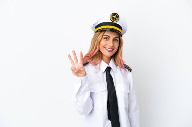 İzole edilmiş beyaz arka planda uçak pilotu mutlu ve parmaklarıyla üçe kadar sayıyor.