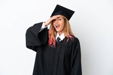 Genç üniversite mezunu, izole edilmiş beyaz bir arkaplan üzerinde sürpriz jest yapıyor.