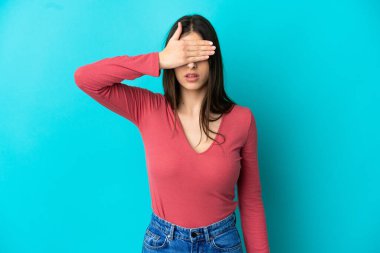 Mavi arka planda, gözleri elle kaplanmış beyaz bir kadın. Bir şey görmek istemiyorum.