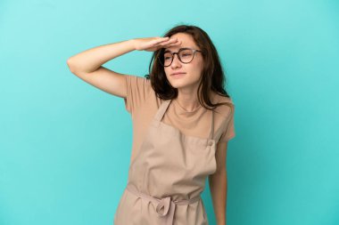 Restoran garsonu bir şeye bakmak için çok uzaklara bakıyor.