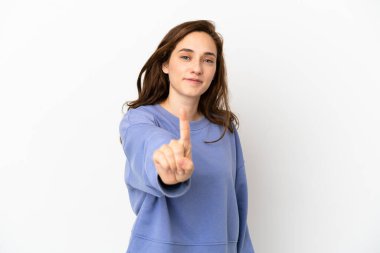 Beyaz arka planda izole edilmiş genç beyaz kadın parmağını kaldırıyor ve gösteriyor.