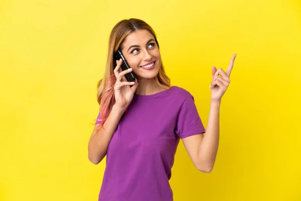Mujer Joven Usando Teléfono Móvil Sobre Fondo Amarillo Aislado Apuntando —  Fotos de Stock