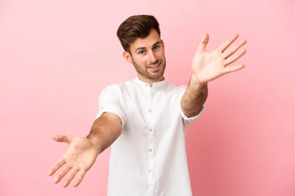 Jonge Blanke Knappe Man Geïsoleerd Roze Achtergrond Presenteren Uitnodigen Komen — Stockfoto