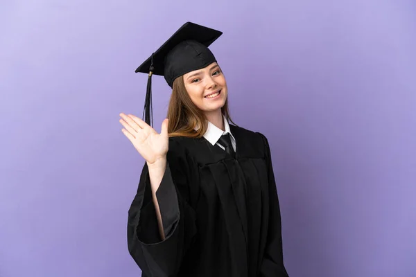 Joven Graduado Universitario Sobre Fondo Púrpura Aislado Saludando Con Mano — Foto de Stock