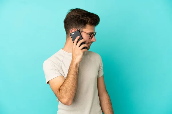 Young Caucasian Handsome Man Isolated Blue Background Keeping Conversation Mobile — Stock Photo, Image