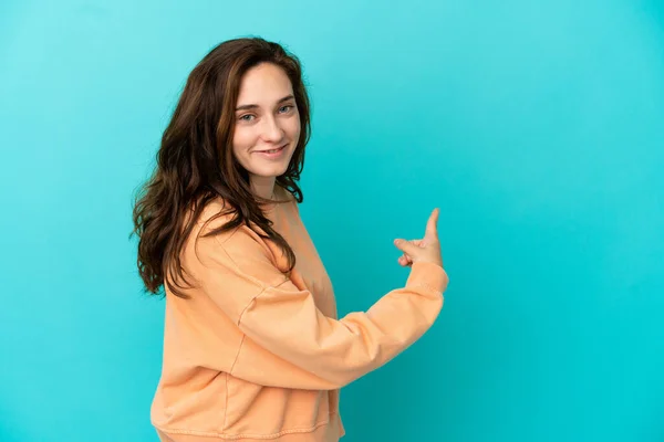 Mujer Joven Caucásica Aislada Sobre Fondo Azul Apuntando Hacia Atrás — Foto de Stock