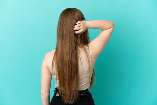 Tiener Meisje Geïsoleerde Blauwe Achtergrond Achterpositie Denken — Stockfoto